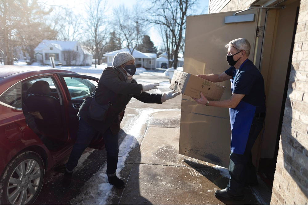 Black Female Volunteer with White Male Volunteer Receiving Meal to Dropoff